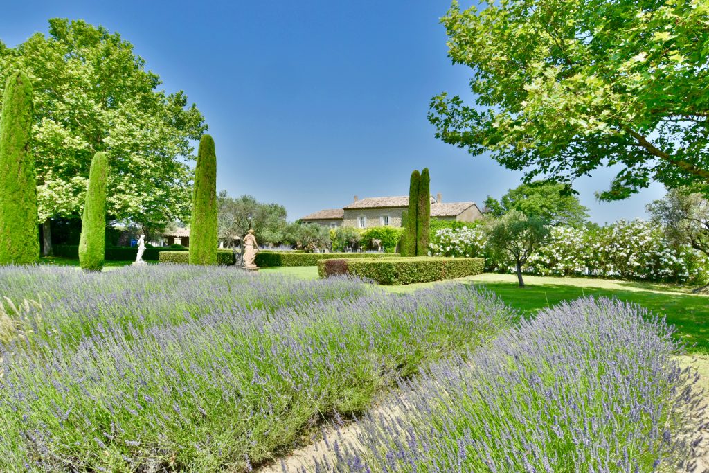 Spring in Provence: Villa Aux Lavandes with lavender fields and emerald lawns under blue skies.