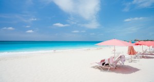 Pink umbrellas on beautiful beach at Providenciales island in Turks and Caicos