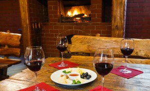 Romantic dinner for two near fireplace - wine and cheese plate. Gastronomy.