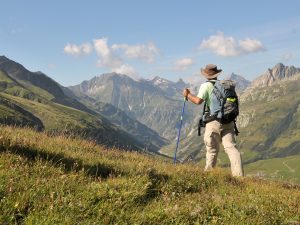 View of Alps mountains and a tourist standing on a footpath. Summer Meribel