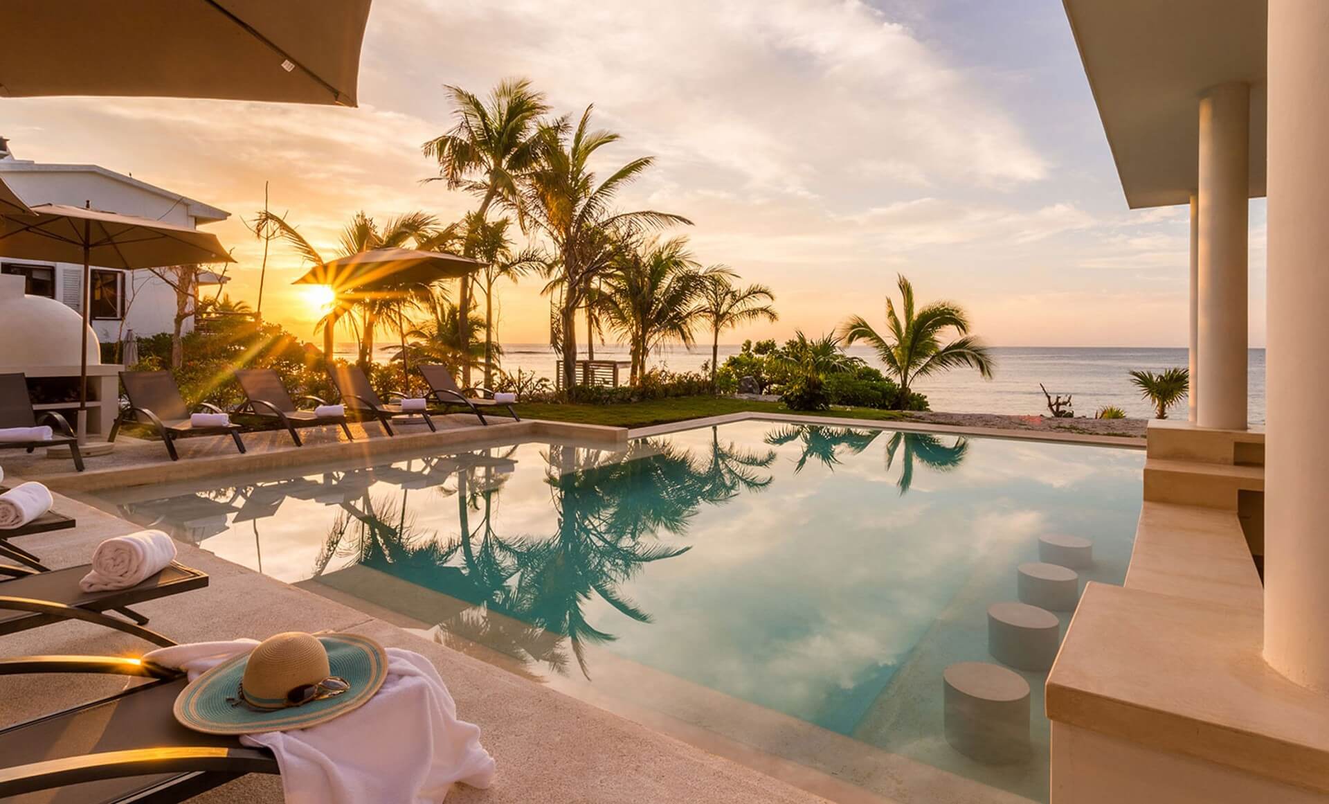 Mayan Riviera travel guide: Casa Milah beachfront pool with sunset ocean views, palms and loungers