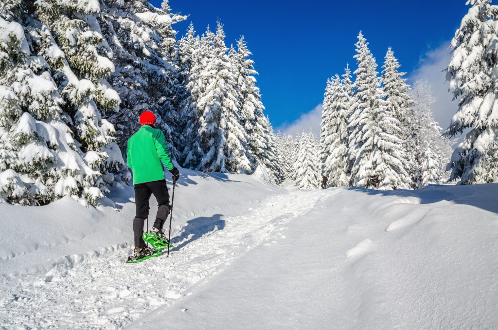 Athletic man with snow shoes on winter trail. Experience Meribel