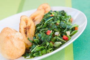 Speciality caribbean dish of callaloo (spinach) served with fried dumplings. Best Caribbean Dishes