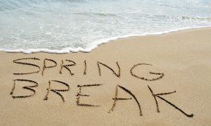 the text spring break written in the sand of a beach. Spring break destinations
