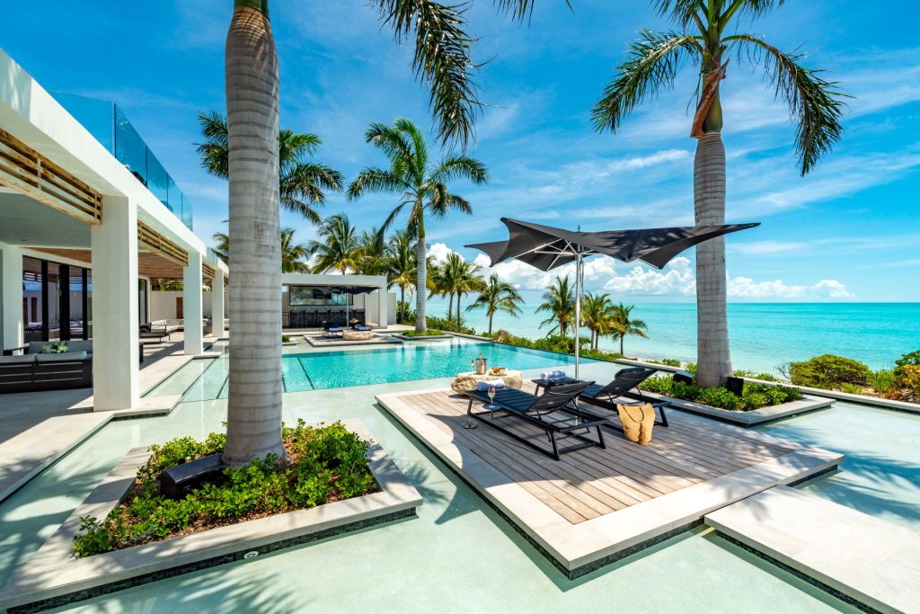 Villa Legasea, a modern luxury Turks & Caicos home with pool, palm trees, and ocean views along the Providenciales coast