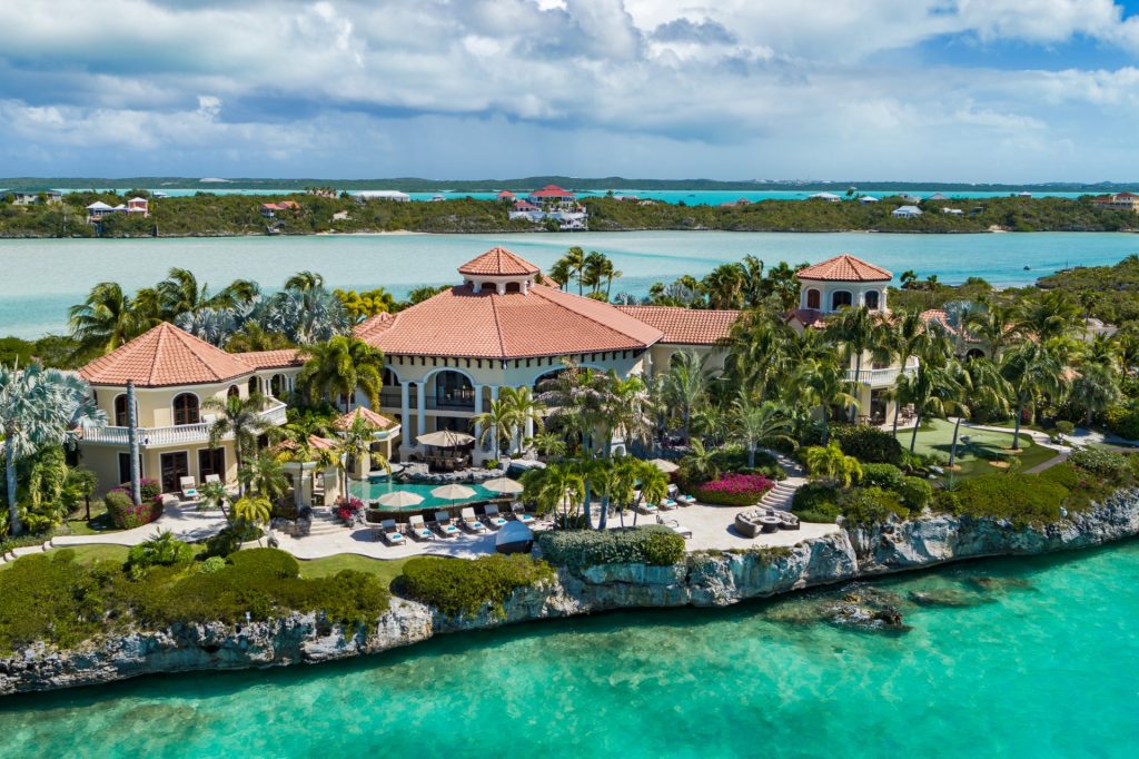 Emerald Cay, a luxury Turks & Caicos home with pool, red-tile roofs, palm trees, and ocean views on a private island estate