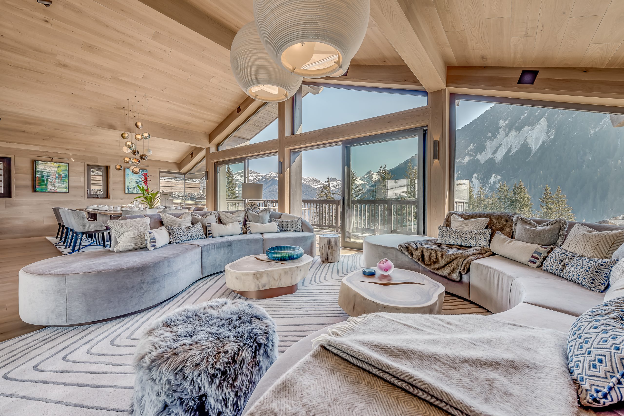Courchevel Ski Resort: Chalet Bacchus features a luxurious living room with a stunning mountain view. Courchevel Ski Resort: Chalet Bacchus features a luxurious living room with a stunning mountain view.