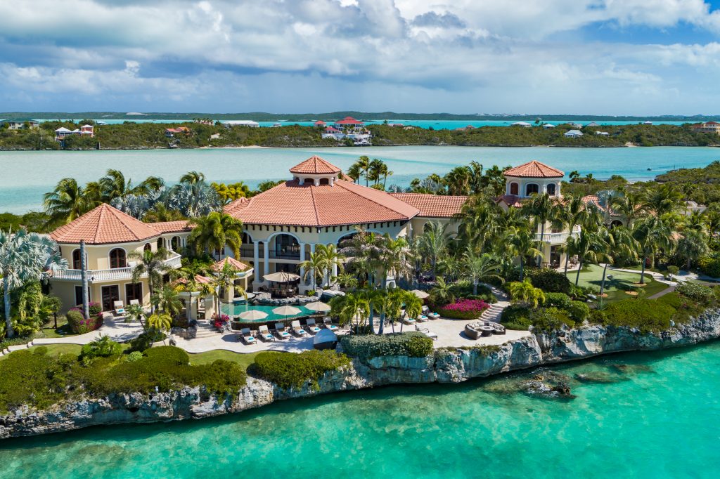 Villas vs. Hotels - Emerald Cay in Turks & Caicos, with pools, ocean access, tennis, and lush landscapes.