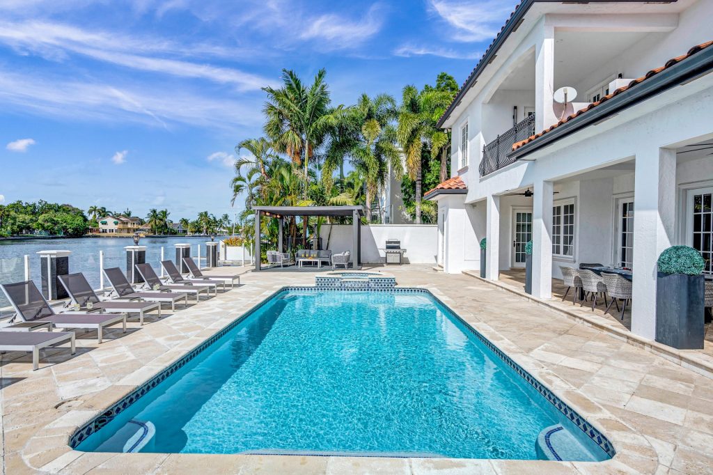 Villa Coral Key's waterfront pool and lounge area, a perfect setting for your South Florida luxury escape.