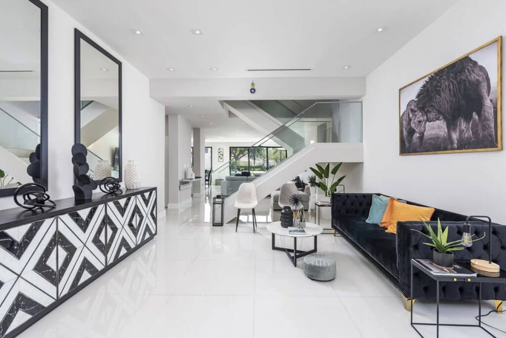 Interior of Florida luxury home with modern decor, black velvet sofa, and bright open-plan living space.