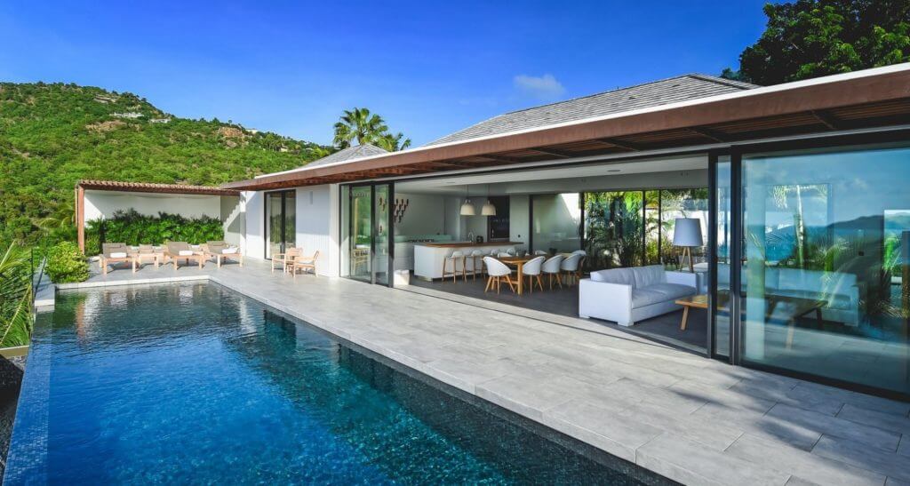 Villa Varuna’s open living space, sleek infinity pool, and tropical hillside views
