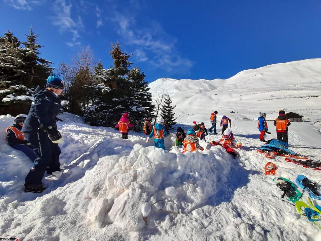 Children learning to ski at Chamonix with instructors, showcasing playful Chamonix Kids Ski Lessons in the French Alps.