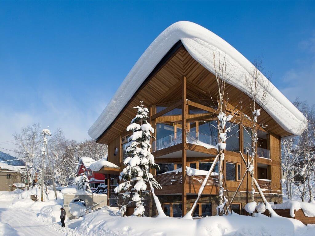 Snow-covered Chalet Seshu with wood and glass design, perfect for alpine escapes.