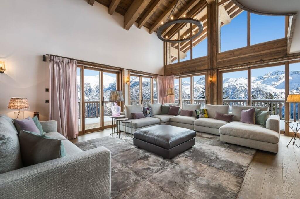 Chalet Libellule in Courchevel, with panoramic alpine views and a cozy lounge.