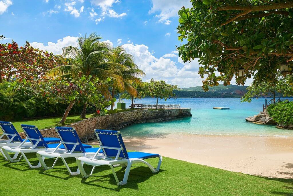 Whispering Waters in Jamaica, a top 10 Christmas holiday destination, with palm trees and turquoise water.
