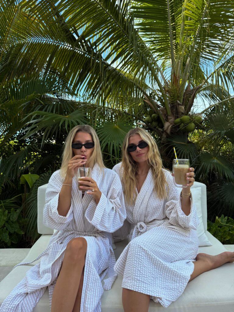 Bridesmaids sipping iced coffee under palm trees