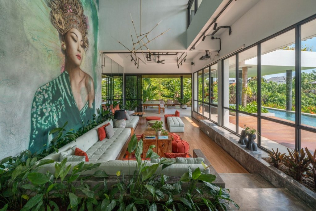 Elegant living room with art mural and infinity pool view at Mandala Oasis in Canggu, one of the 7 reasons to visit Bali.