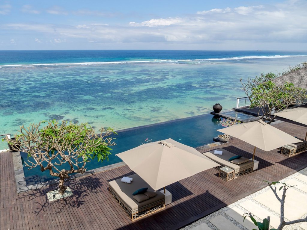 Villa Cliff Nusa Dua Bali infinity pool with loungers overlooking the turquoise ocean, part of the New Isle Blue Rewards.