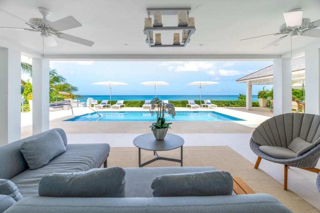One of the Best Places to Travel in December: Blue Oyster luxury villa with oceanfront pool, sun loungers, and sea views.