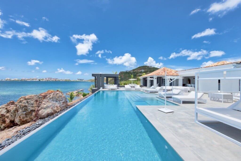 Best Places to Travel in December: Villa Mirabelle in St. Martin with infinity pool, modern loungers, and ocean views.