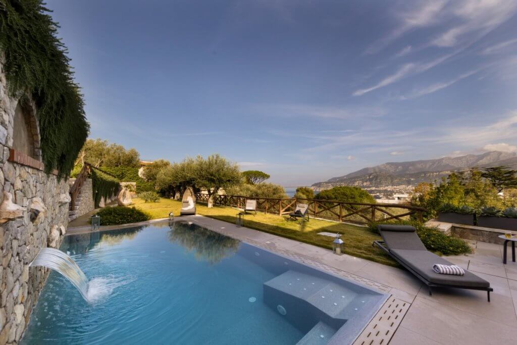 Private pool at Grandalba villa on Amalfi Coast with waterfall wall and panoramic coastal views.