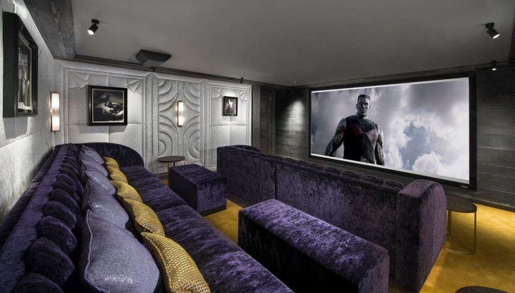 Chalet Coquelicot’s cinema lounge with plush seating, ambient lighting, and a full-size private screen.