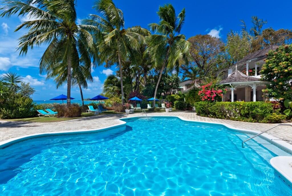 Emerald Beach 4, Barbados: tropical villa pool surrounded by palm trees, sun loungers, and ocean views.