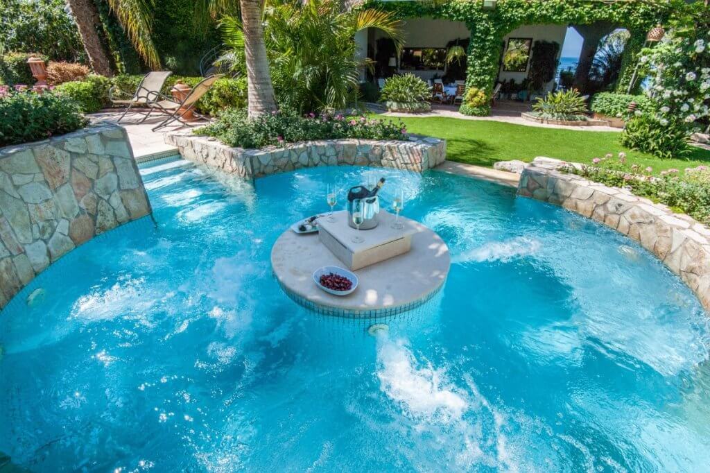 Luxury villa vacation with kids at Ninella, Sicily, spa pool with champagne, snacks, and lush garden.