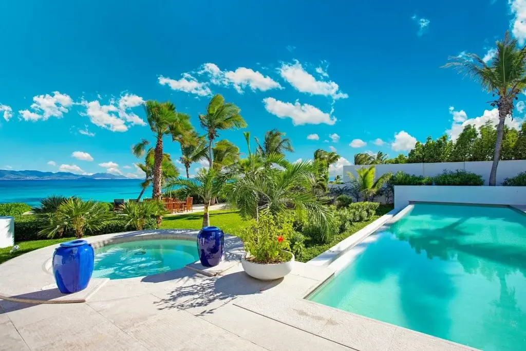 Oceanfront pool and landscaped gardens at Villa Rendezvous, Anguilla, illustrating private villas in Anguilla with open coastal views.