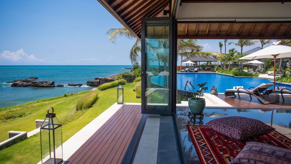 Oceanfront Tirtha Bayu Villa II with infinity pool and open pavilion showcases a serene private villa stay vs. resort experience.