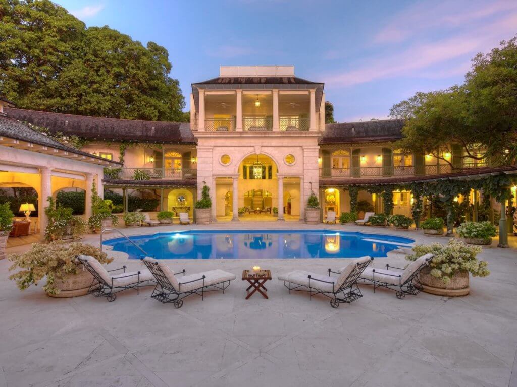 Laughing Waters Barbados villa courtyard with classical architecture, oval pool, and twilight ambiance.