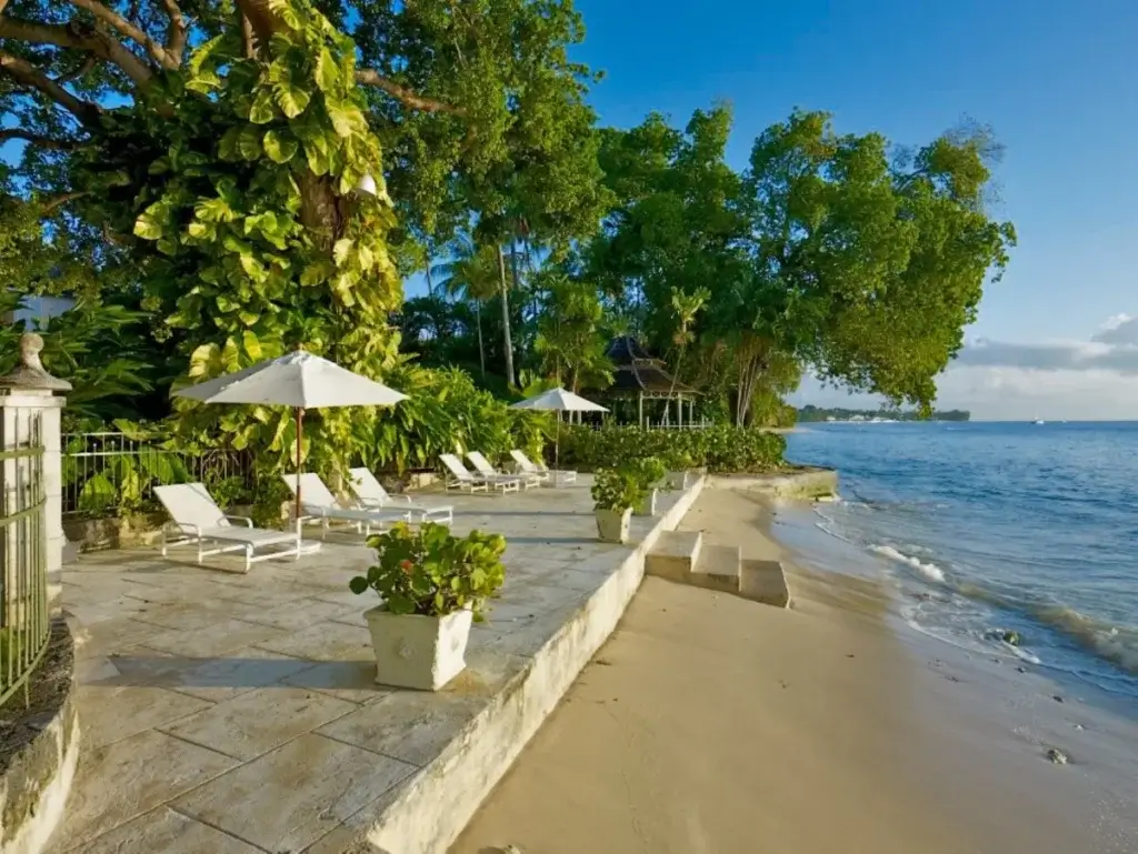 Mango Bay, Barbados luxury villas with direct beach access, private loungers, shaded terrace, and calm shoreline setting.