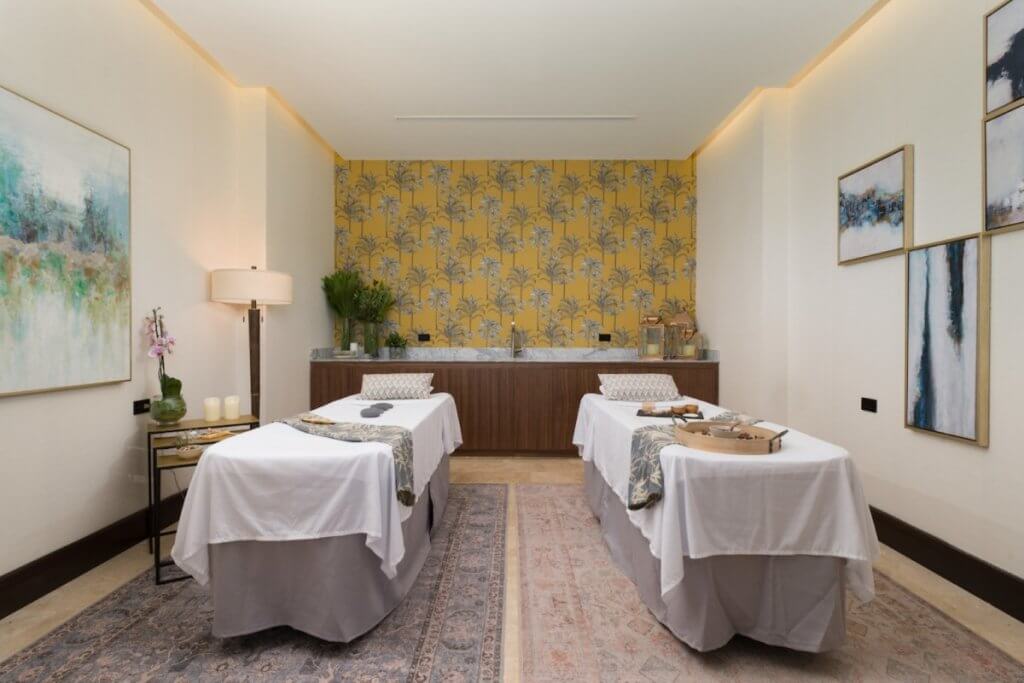 Spa room at The Hive, Costa Rica, with twin massage tables, botanical accents, and luxury wellness amenities.