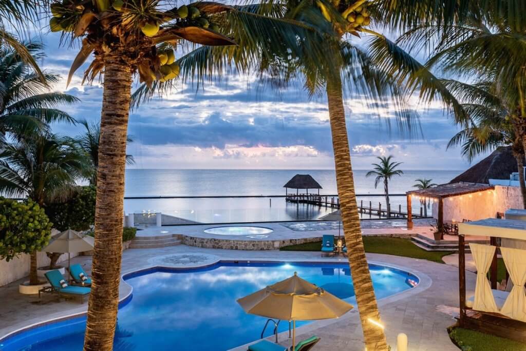 Oceanfront pool and palm-lined terrace at Villa Corona, a Mayan Riviera warm-weather villa.