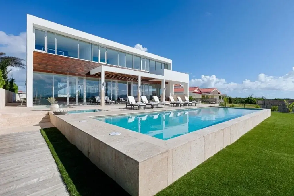 Modern private pool at Beaches Edge East, with glass architecture and sun loungers.