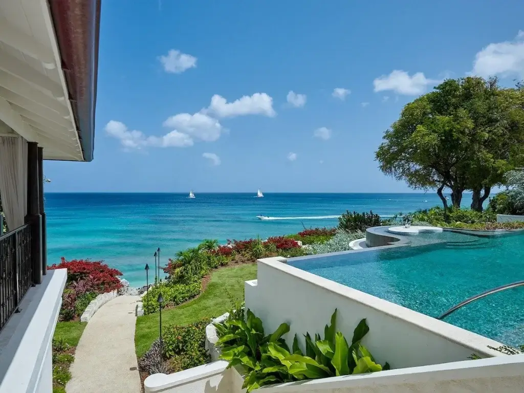 Infinity edge pool at Seaclusion overlooking the Caribbean Sea with garden path to the beach.