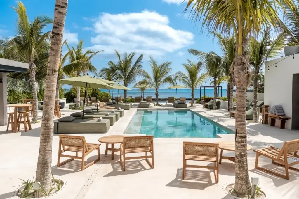 Palm-framed oceanfront pool lounge at Hacienda Jaguar, a spring break private villa without the crowds in Mayan Riviera.