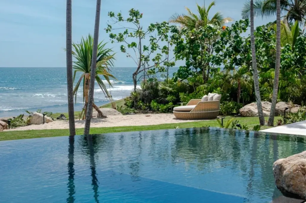 Oceanfront infinity pool and garden lounge at Casa Xielo, Punta Mita, reflecting Mexico or the Caribbean luxury travel through space and privacy.