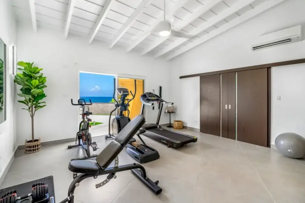 Ocean-view fitness room at La Villa Salee designed for a seamless St Martin stay with treadmill and exercise bike.