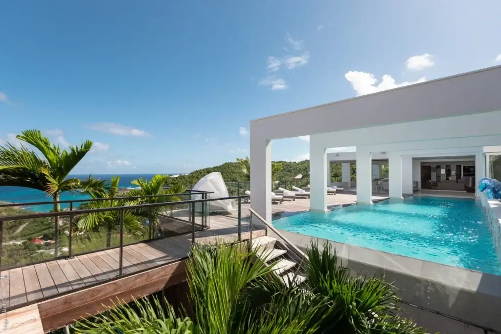 Villa Eclipse (JNM), St Barts infinity pool terrace with ocean views, glass railing deck and modern open-air architecture