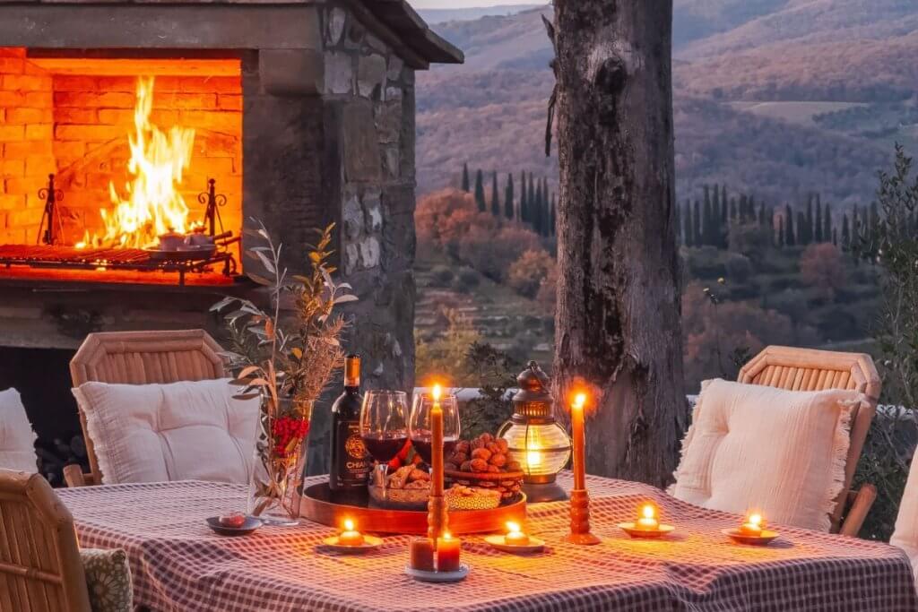Where to stay in Tuscany at Le Rondini with outdoor dining, fireplace, and vineyard views at sunset