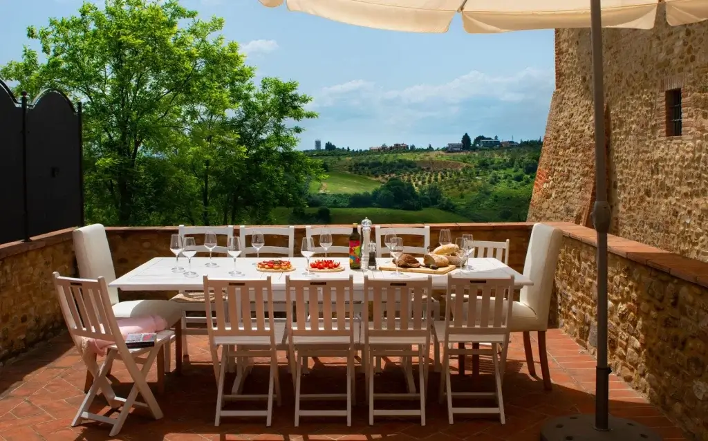 Italian summer escapes Villa Beltrude Tuscany outdoor dining terrace with vineyard views