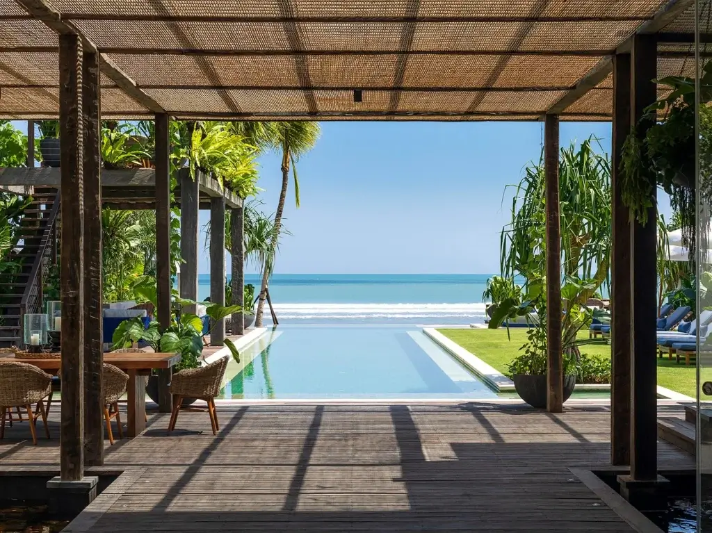 Beachfront infinity pool and open-air lounge at Noku Beach House, Bali among Bali villas this season