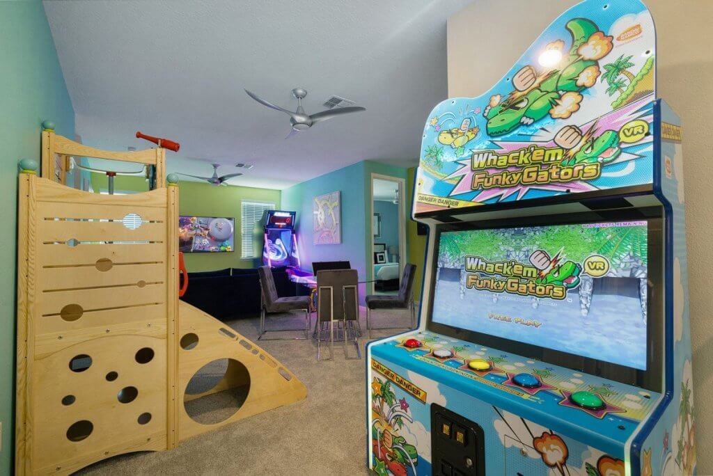 Kids activity room at Enchanted Estate Orlando with arcade games, climbing playset, and family entertainment