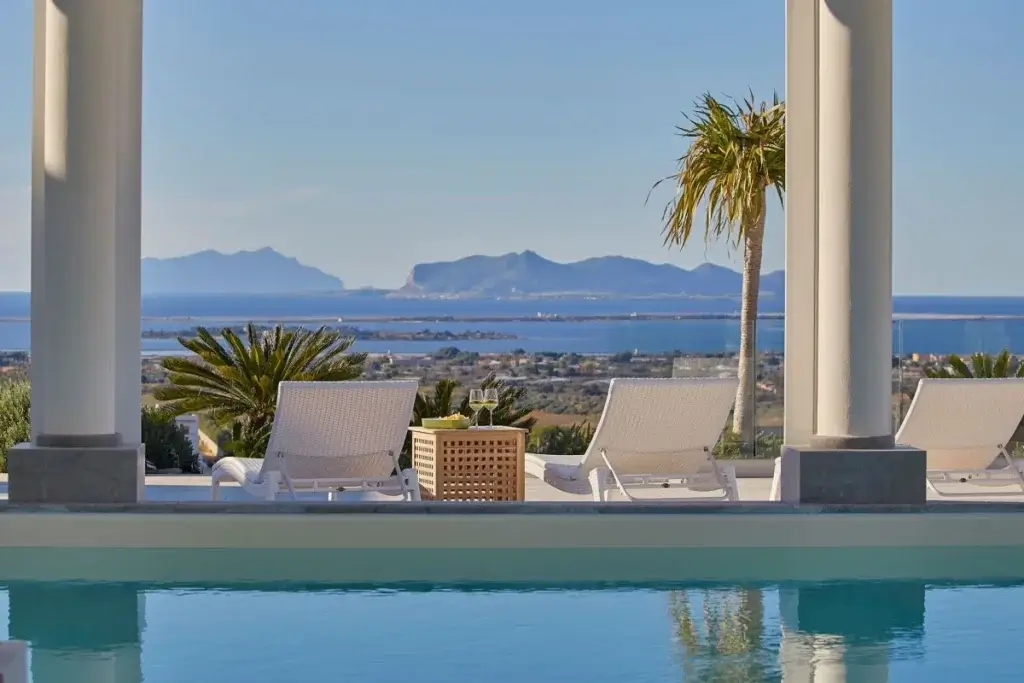 Luxury villa pool terrace at Seven Islands Sicily with panoramic sea views, lounge chairs, and coastal scenery