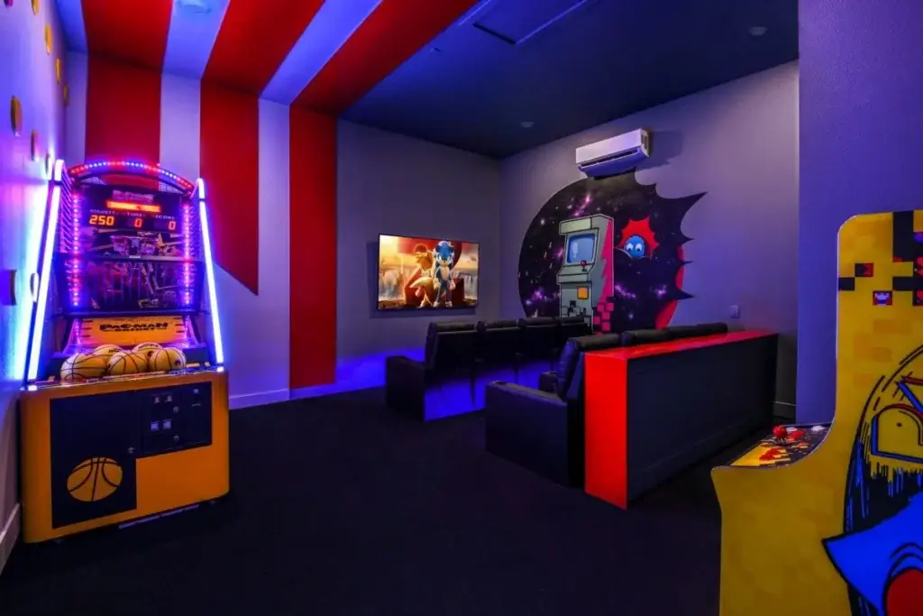 Arcade-style theater room at Celestial Castle Orlando with neon gaming décor and cinema seating in a luxury Orlando villa