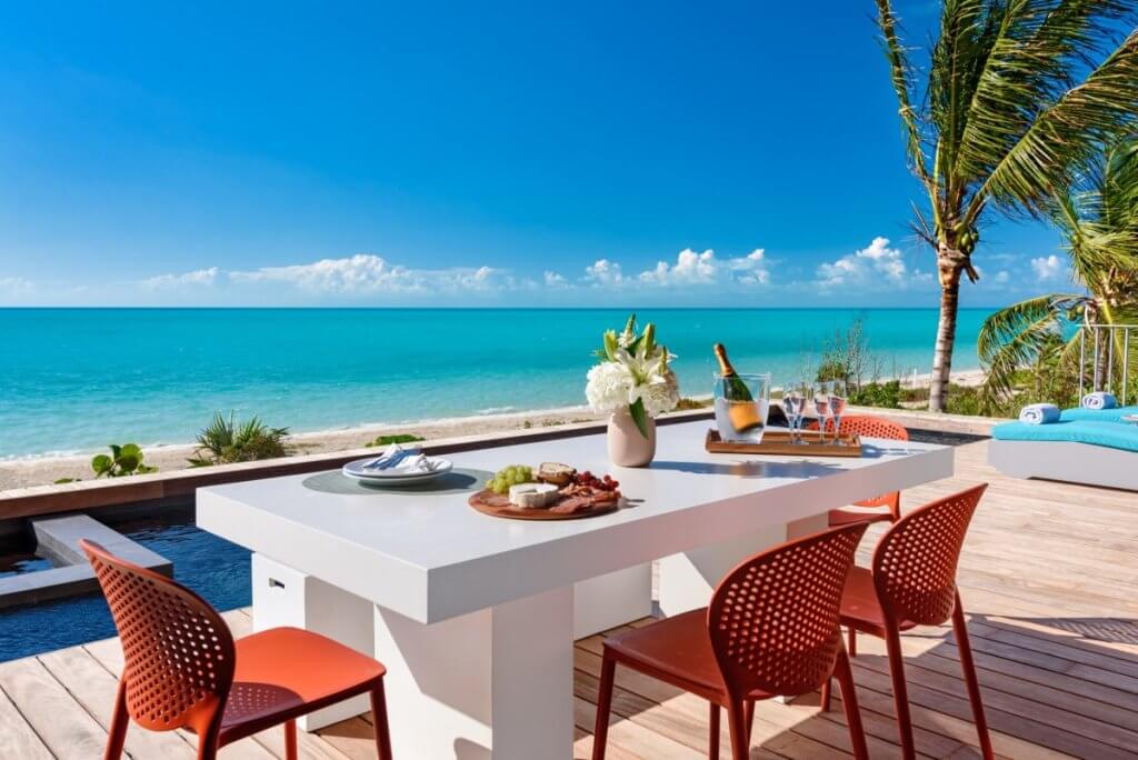 Umi’s oceanfront dining terrace with champagne, a private pool and sweeping Long Bay Beach views.