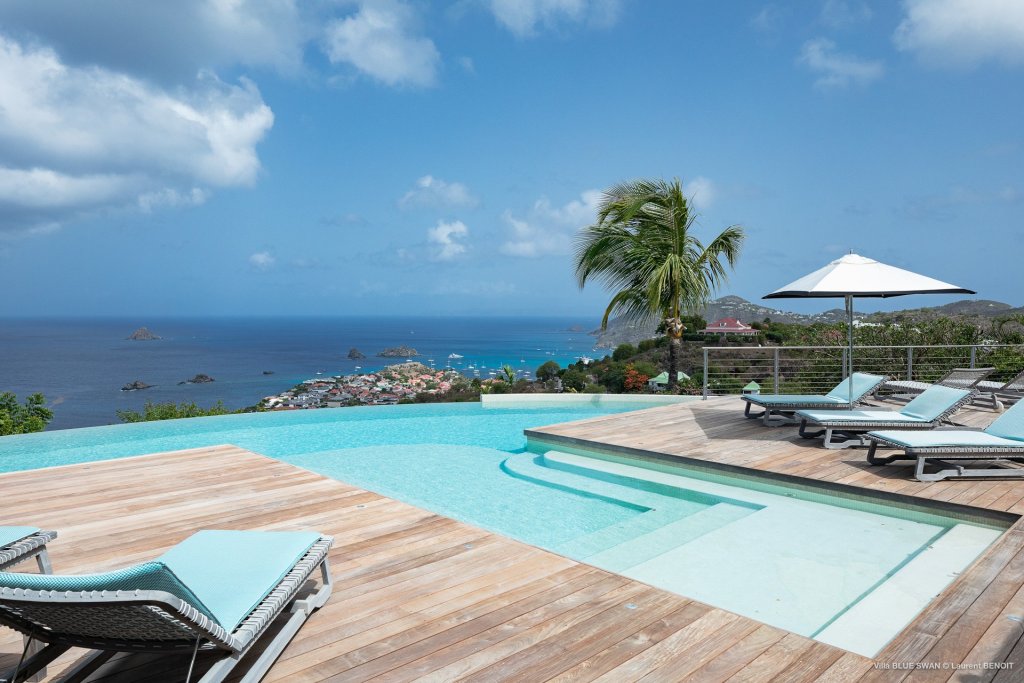 Blue Swan curved infinity pool, timber deck, loungers and panoramic St Barts bay views