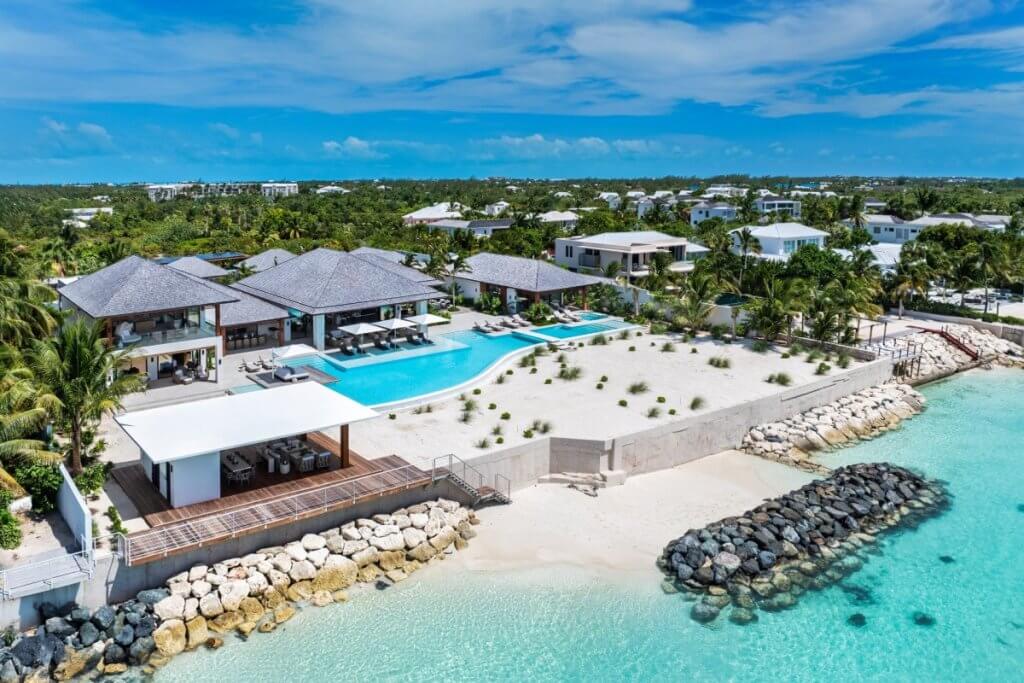 Aerial view of Footprints TCI, one of the best Caribbean villas, with a private pool beside turquoise water.